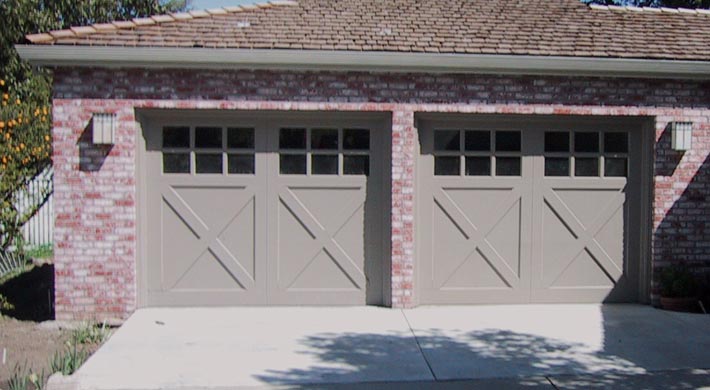 Two car garage with carriage house style garage doors and pink brick siding