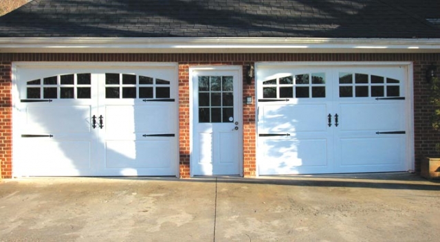Garage with two white garage doors and one entry door in the center