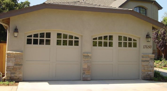 Garage with stone and stucco siding and two carriage house style garage doors with windows