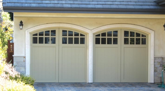 Two carriage house garage doors with arched top and no visible hardware