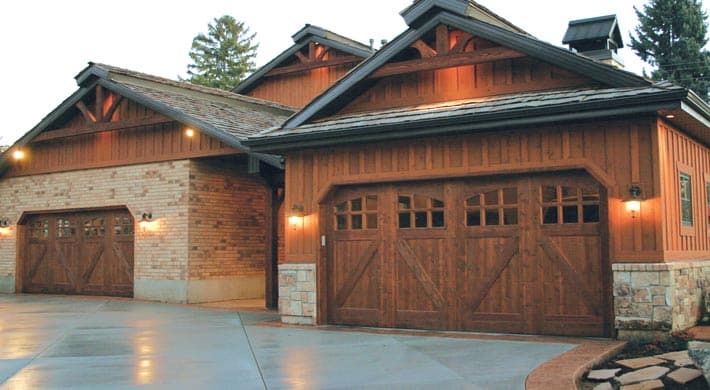 Rustic home with wood batten board siding and wood garage doors
