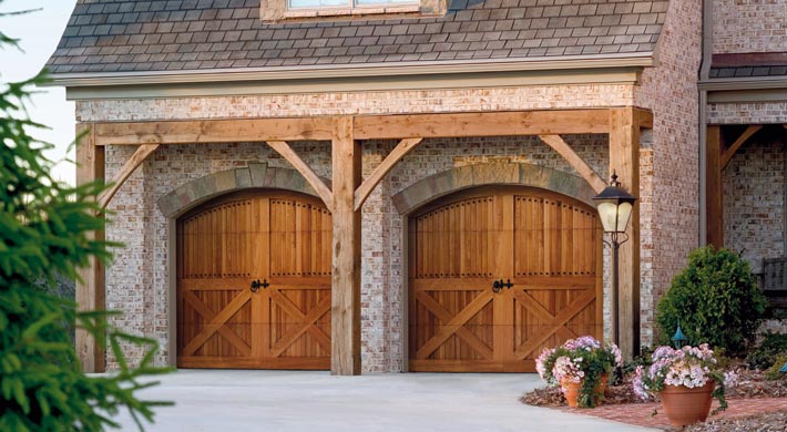 Attached garage with brick siding and custom stained carriage house style garage doors