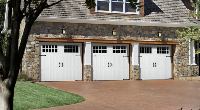 Three car garage with three white carriage house style garage doors