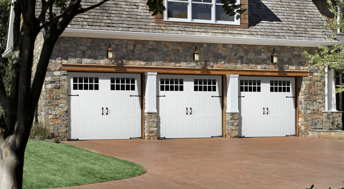 Three car garage with three white carriage house style garage doors