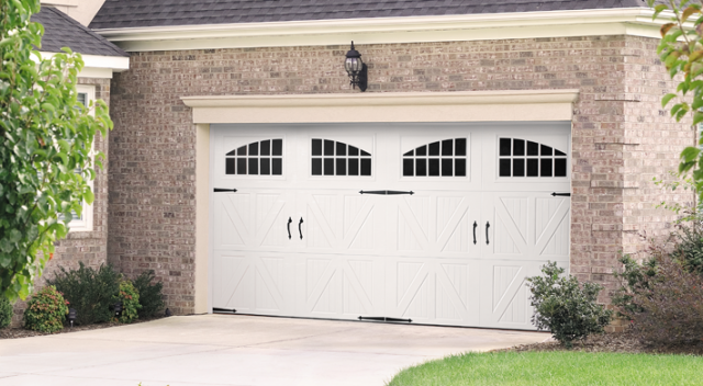 White carriage house garage doors with arched windows in the top panel