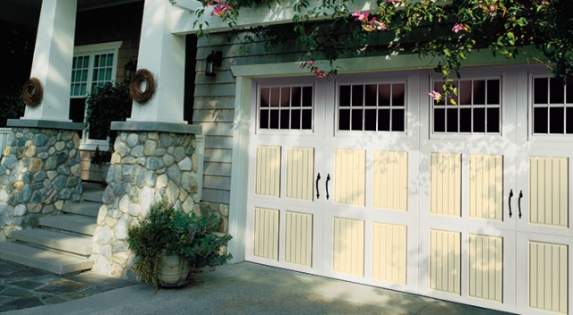Light yellow and white carriage house style garage doors on mixed-facade home