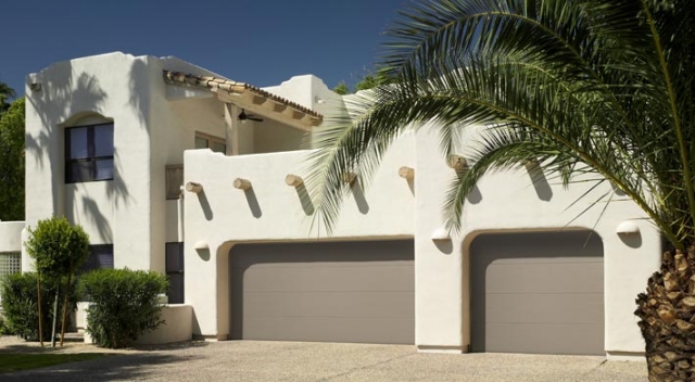 Two flush garage doors on modern spanish style house