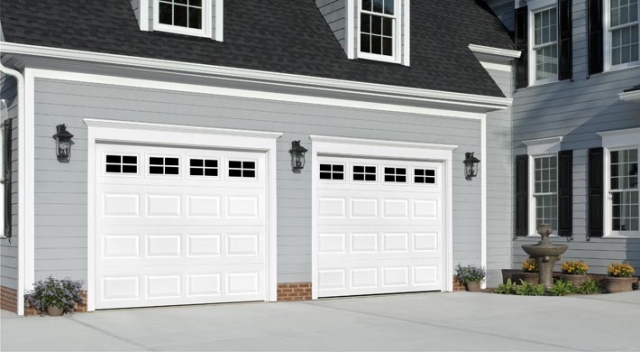Attached garage with gray lap siding and two white garage doors