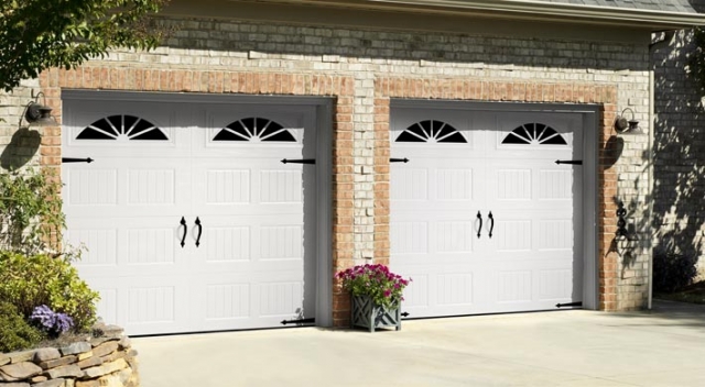 Two car garage with two carriage house style garage doors with wagonwheel windows