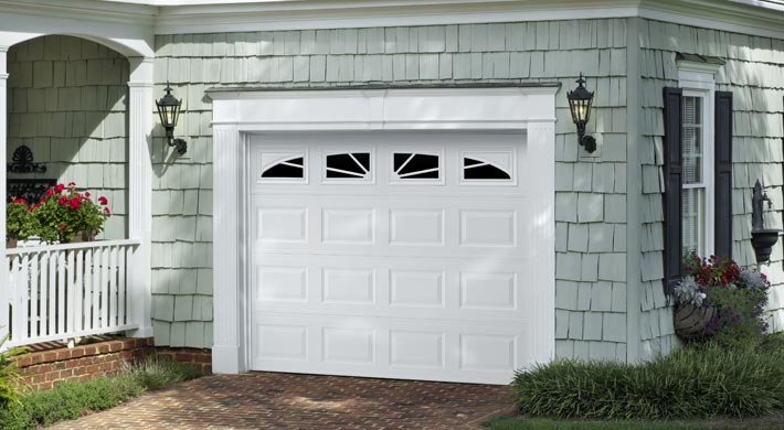 Short panel garage door with windows on house with shake shingles