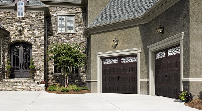 two story house with grand entry door and two garage doors