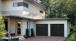 two story house with two car garage with dark garage doors
