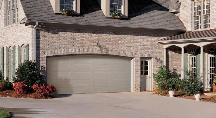 Two car garage with arched opening on brick house