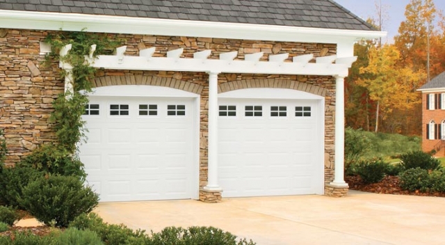 Attached two car garage with stone siding  and white overhang