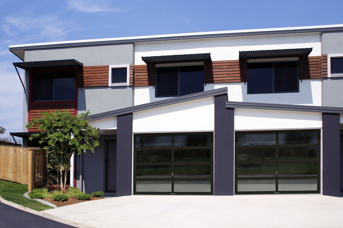 Modern home with high contrast design and dark specialty garage door frames