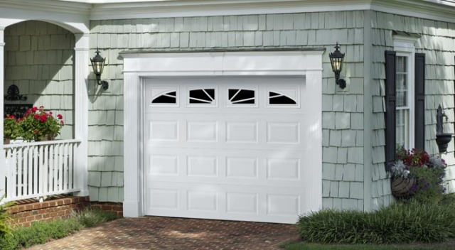 Short panel garage door in white on house with shake shingle siding