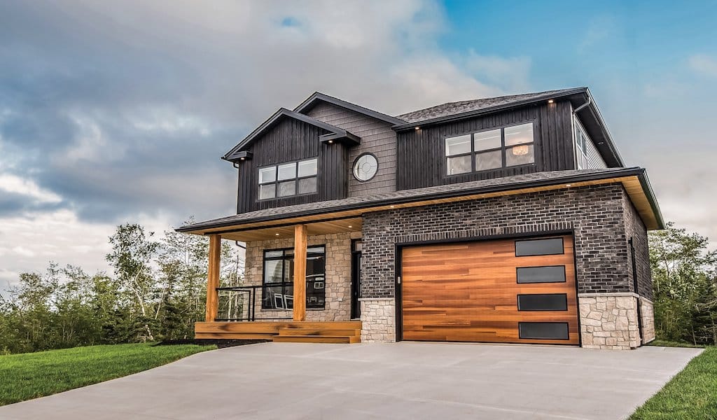 Two-story mixed material home with wood patio, soffit, and wood panel CHI garage door. Image for Best Garage Door Brands post.