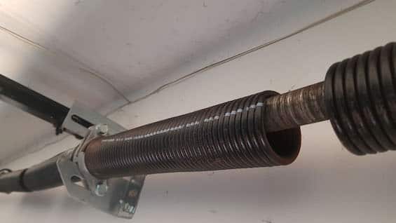 Example of a broken garage door torsion spring. Spring broken closer to the right end of the coil.