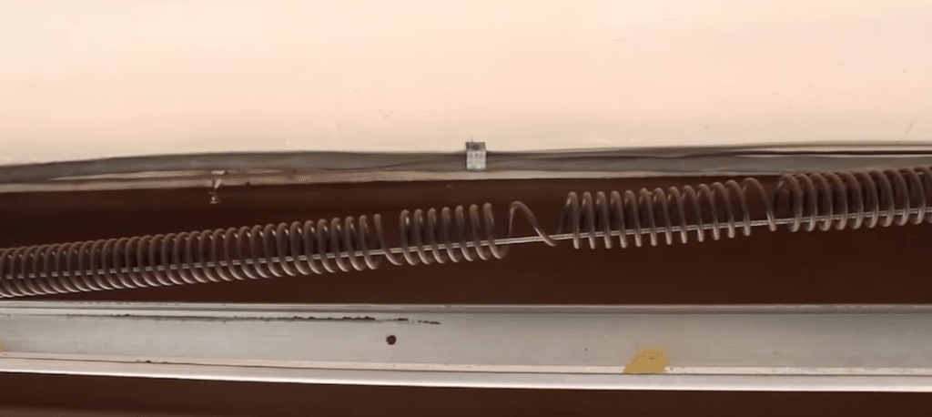Stretched out garage door spring with gap between coils.